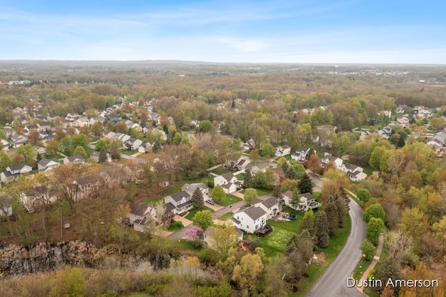 aerial overview of property's location featuring nearby suburban area and a forest