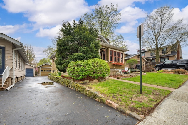 view of property exterior with an outdoor structure, a yard, and a garage