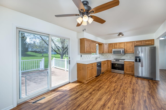 kitchen with visible vents, light countertops, dark wood finished floors, appliances with stainless steel finishes, and backsplash