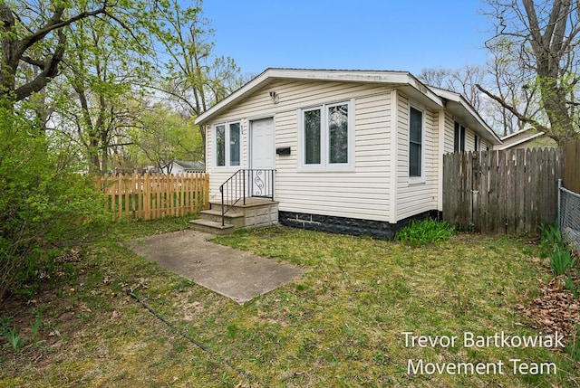 bungalow-style house featuring fence and a front yard