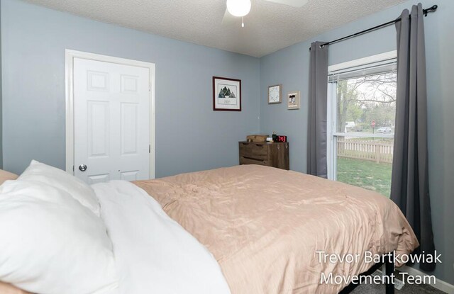 bedroom with access to outside, a ceiling fan, and a textured ceiling