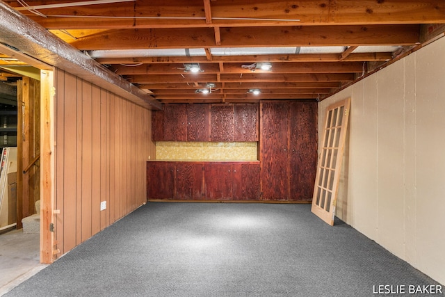 basement with carpet floors and wood walls