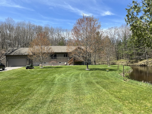 6425 S Taylor Rd, Branch, MI 49402 - view of front of property with a garage, a water view, driveway, and a front lawn