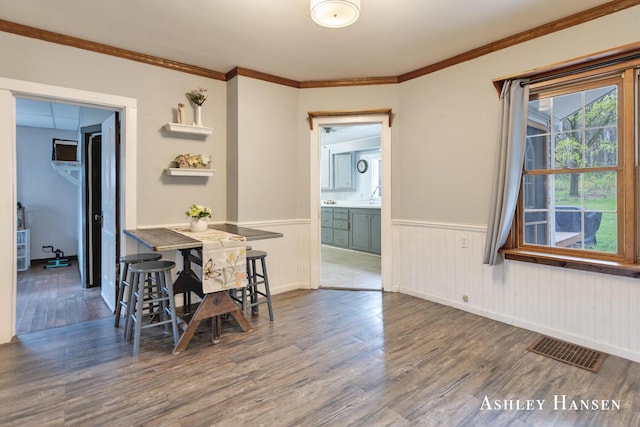 12978 Mason Dr, Grant, MI 49327 - dining area featuring ornamental molding, wainscoting, wood finished floors, and visible vents