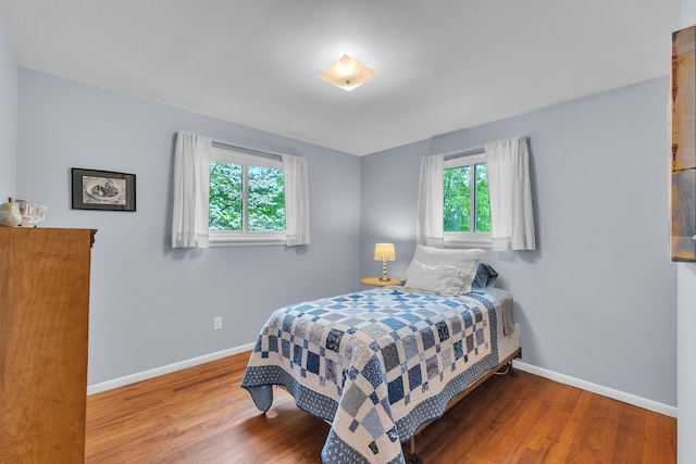 3622 Cushing Ct, Dexter, MI 48130 - bedroom with baseboards, wood-type flooring, and multiple windows