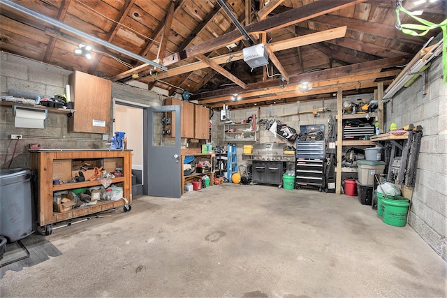 garage featuring concrete block wall, a workshop area, and a garage door opener