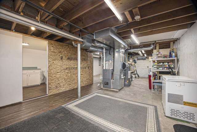 unfinished below grade area with heating unit and gas water heater