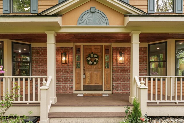 326 Greentree Ln NE, Ada, MI 49301 - property entrance featuring a porch and brick siding