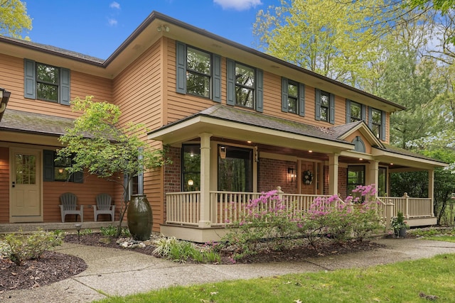 326 Greentree Ln NE, Ada, MI 49301 - view of front of home with a porch and brick siding