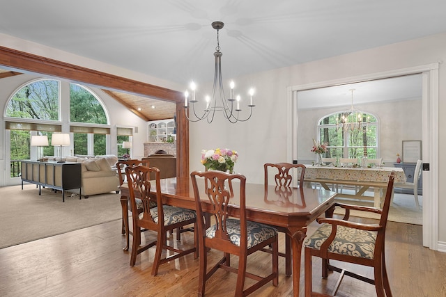 326 Greentree Ln NE, Ada, MI 49301 - dining room featuring a chandelier, plenty of natural light, lofted ceiling, and wood finished floors
