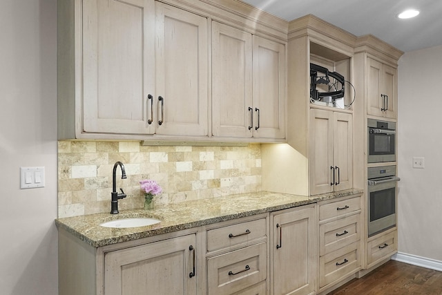 326 Greentree Ln NE, Ada, MI 49301 - kitchen featuring a sink, decorative backsplash, light stone counters, and cream cabinets