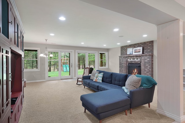 326 Greentree Ln NE, Ada, MI 49301 - living room featuring light colored carpet, baseboards, recessed lighting, a brick fireplace, and a chandelier