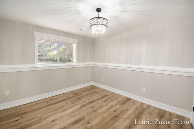 1791 Gloryfield Dr, Byron Center, MI 49315 - empty room featuring a chandelier, wood finished floors, and baseboards