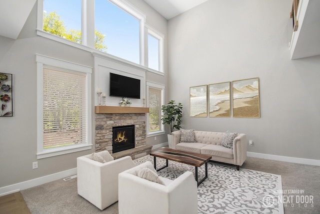 1791 Gloryfield Dr, Byron Center, MI 49315 - carpeted living area featuring a towering ceiling, a stone fireplace, and baseboards