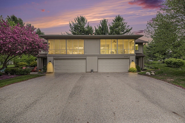 4289 Millpond Dr NE, Rockford, MI 49341 - view of front facade with an attached garage, driveway, and a sunroom