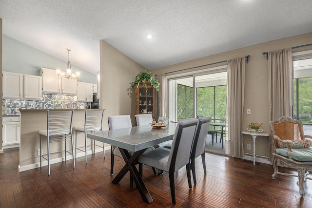 4289 Millpond Dr NE, Rockford, MI 49341 - dining room with vaulted ceiling, a textured ceiling, dark wood finished floors, and a chandelier