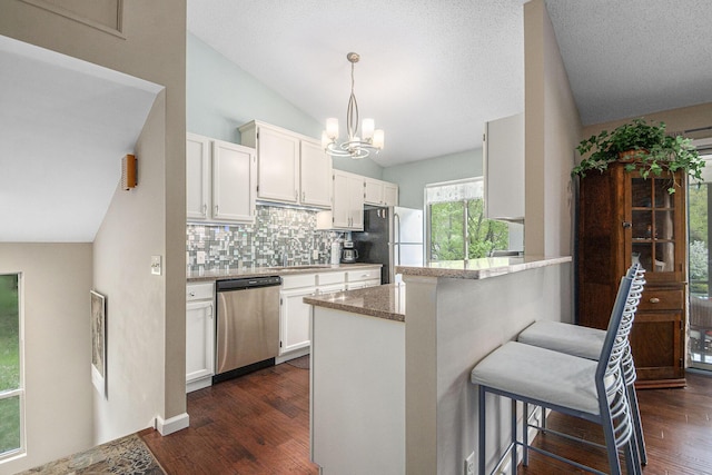 4289 Millpond Dr NE, Rockford, MI 49341 - kitchen featuring stainless steel appliances, vaulted ceiling, backsplash, white cabinets, and a breakfast bar area