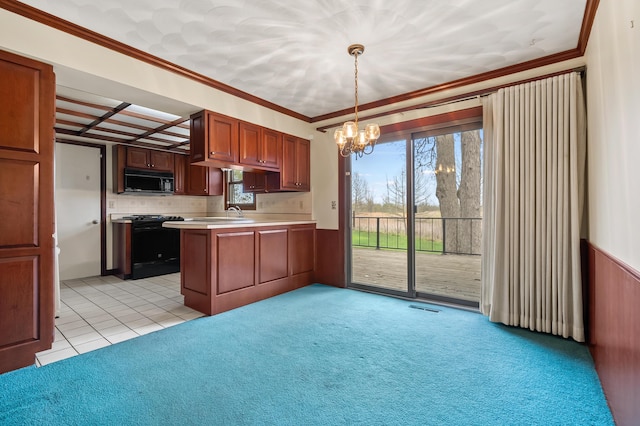 416 Barberry Ave, Portage, MI 49002 - kitchen featuring a peninsula, black microwave, light countertops, a chandelier, and range with gas cooktop