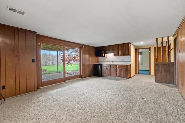 416 Barberry Ave, Portage, MI 49002 - unfurnished living room featuring light colored carpet, wood walls, and visible vents