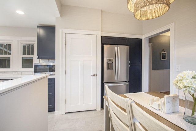 kitchen featuring recessed lighting, light countertops, light tile patterned floors, a notable chandelier, and stainless steel appliances