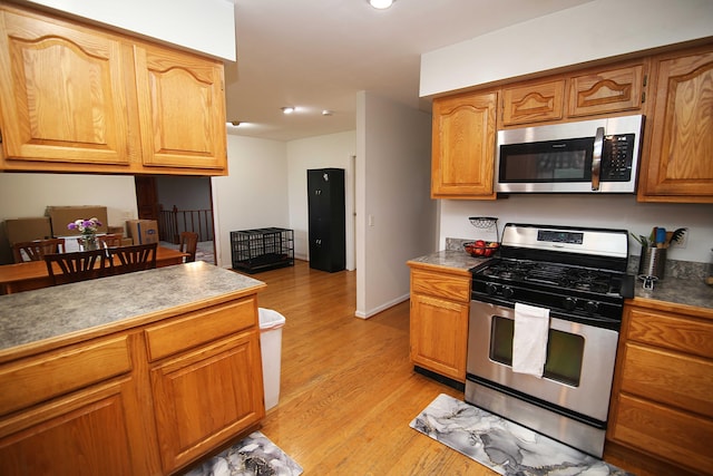 53240 Hemlock Lake Rd, Marcellus, MI 49067 - kitchen with appliances with stainless steel finishes, light wood finished floors, recessed lighting, brown cabinets, and baseboards