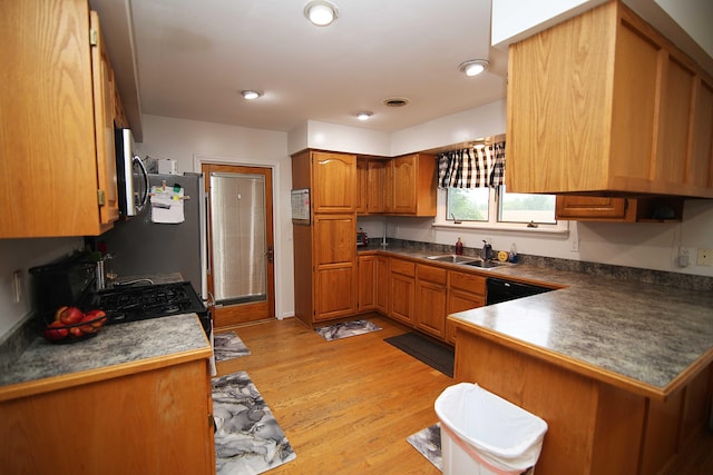 53240 Hemlock Lake Rd, Marcellus, MI 49067 - kitchen with a sink, brown cabinetry, light wood-type flooring, a peninsula, and appliances with stainless steel finishes