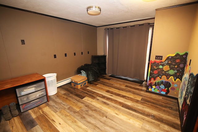 53240 Hemlock Lake Rd, Marcellus, MI 49067 - empty room with wood finished floors, a textured ceiling, a baseboard radiator, and crown molding
