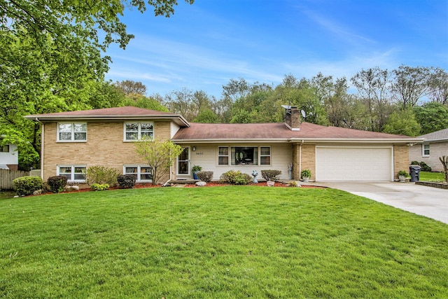 tri-level home with an attached garage, a front yard, a chimney, and concrete driveway