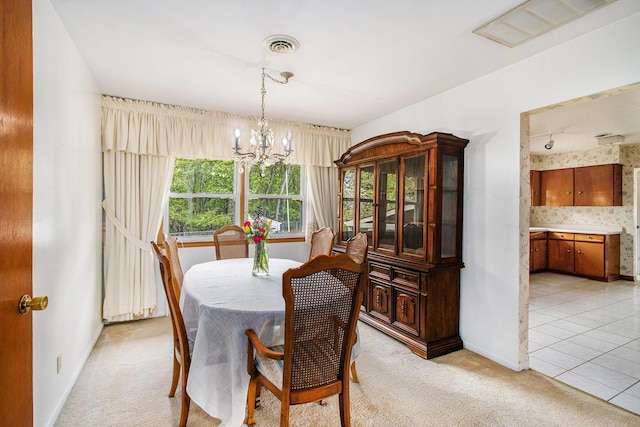 dining area featuring baseboards, visible vents, light carpet, and a notable chandelier