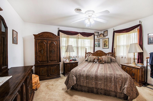 bedroom featuring ceiling fan, multiple windows, and light carpet