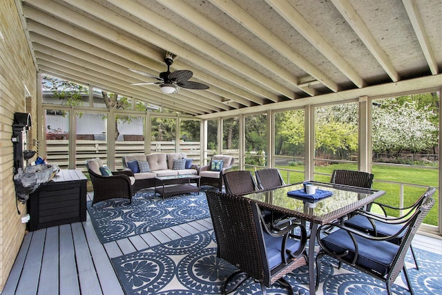 sunroom / solarium with a healthy amount of sunlight, an outdoor living space, and a ceiling fan