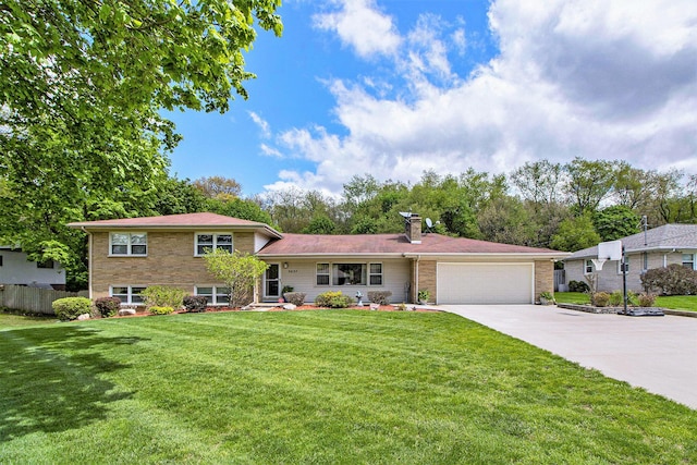5037 Greenhill St, Portage, MI 49024 - split level home featuring a garage, concrete driveway, a chimney, and brick siding
