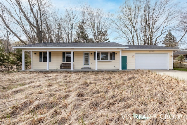 view of front of home with covered porch, an attached garage, and concrete driveway