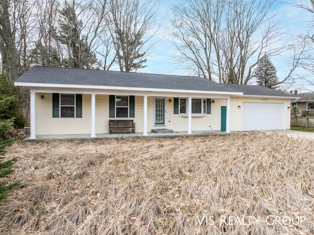ranch-style house featuring covered porch, an attached garage, concrete driveway, and a shingled roof