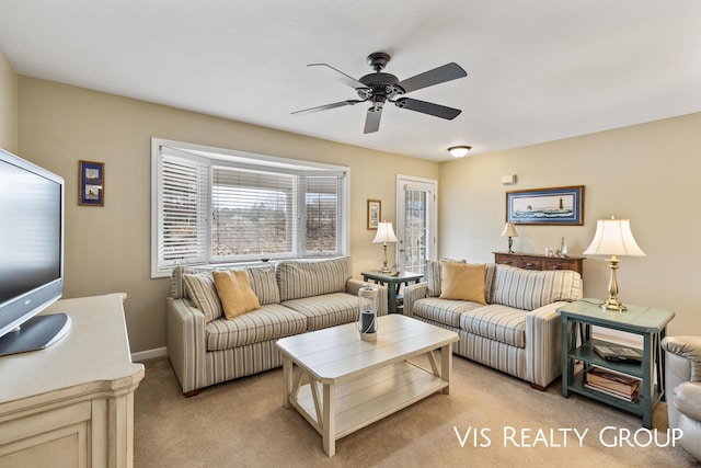 living room featuring light colored carpet, a ceiling fan, and baseboards