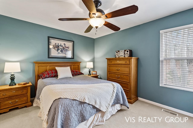 bedroom featuring baseboards, ceiling fan, light carpet, and visible vents