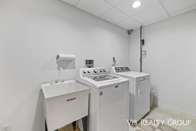 washroom with independent washer and dryer, laundry area, a sink, baseboards, and light tile patterned floors