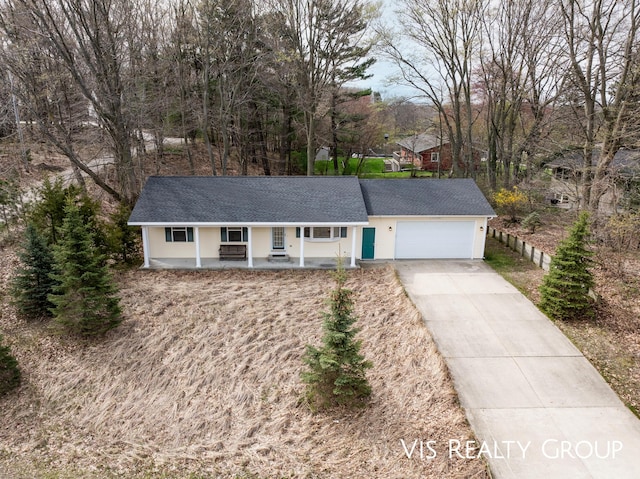 view of front facade with a porch, concrete driveway, and a garage