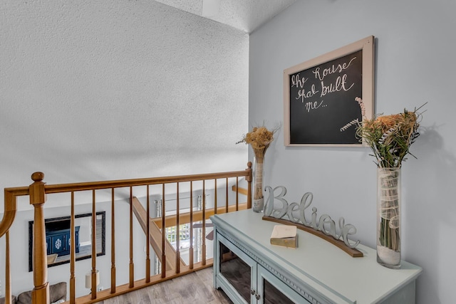 109 Diversy Dr, Brooklyn, MI 49230 - corridor with light wood-style floors, a textured ceiling, and an upstairs landing