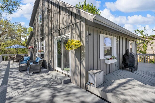 109 Diversy Dr, Brooklyn, MI 49230 - view of property exterior featuring board and batten siding, a deck, and outdoor dining space