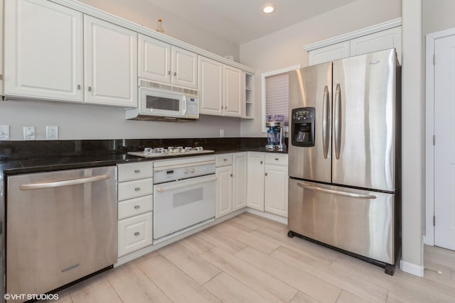 257 Shoreview Way Unit 9, Saint Joseph, MI 49085 - kitchen featuring appliances with stainless steel finishes, dark countertops, white cabinetry, open shelves, and light wood finished floors