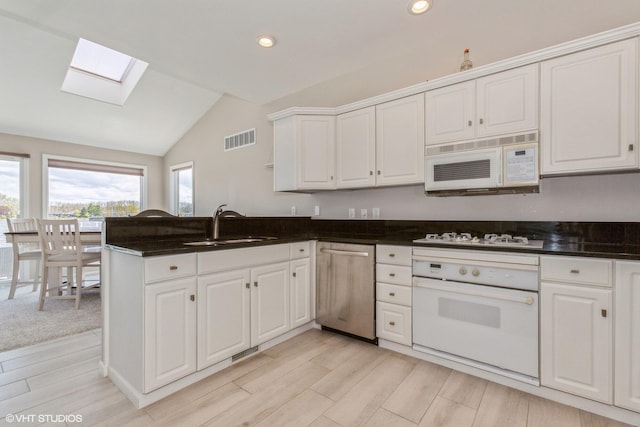 257 Shoreview Way Unit 9, Saint Joseph, MI 49085 - kitchen with white appliances, a skylight, a sink, lofted ceiling, and a peninsula