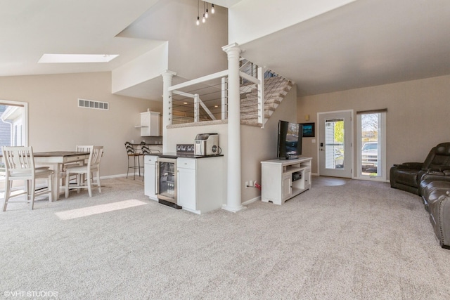 257 Shoreview Way Unit 9, Saint Joseph, MI 49085 - living room with wine cooler, light carpet, baseboards, a skylight, and high vaulted ceiling