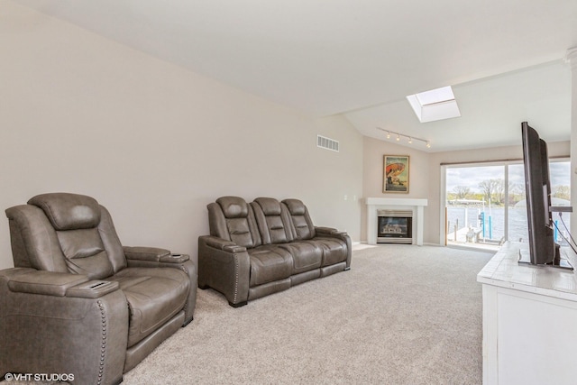 257 Shoreview Way Unit 9, Saint Joseph, MI 49085 - living room with a skylight, light colored carpet, a glass covered fireplace, and rail lighting