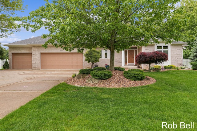 4524 Hidden Ridge Dr, Hudsonville, MI 49426 - obstructed view of property with an attached garage, concrete driveway, a front lawn, and brick siding