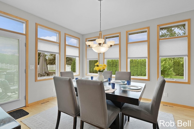4524 Hidden Ridge Dr, Hudsonville, MI 49426 - dining room with a chandelier, wood finished floors, and baseboards