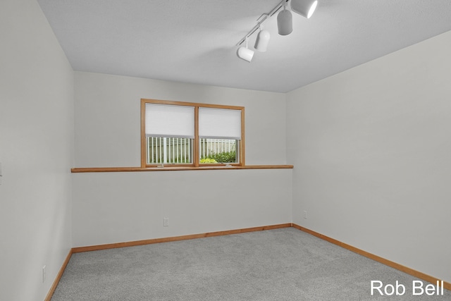 4524 Hidden Ridge Dr, Hudsonville, MI 49426 - spare room featuring carpet flooring, baseboards, and rail lighting