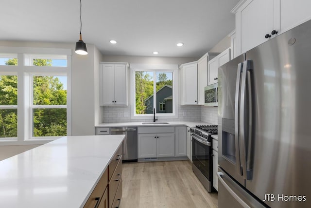 5416 Albright Ave SW Unit 39, Wyoming, MI 49418 - kitchen with appliances with stainless steel finishes, decorative backsplash, light wood-type flooring, decorative light fixtures, and recessed lighting