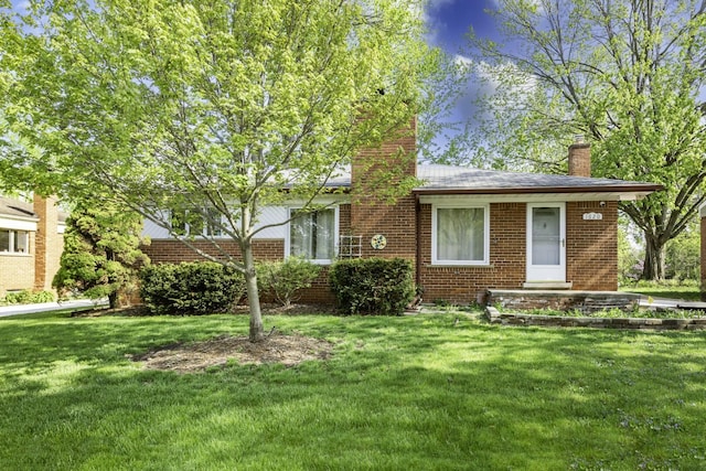 1620 Whittier Rd, Ypsilanti, MI 48197 - view of front of house with a chimney, brick siding, and a front yard