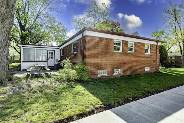 1620 Whittier Rd, Ypsilanti, MI 48197 - view of side of property featuring a yard, brick siding, and a sunroom